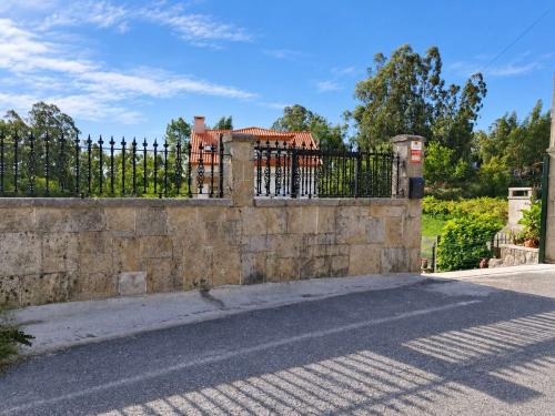 Cierre exterior de piedra y acceso a Villa Merchy en Combarro