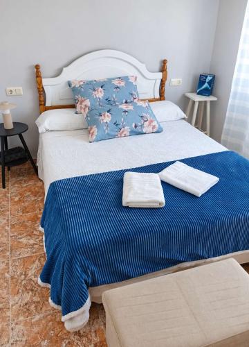 Dormitorio doble de Villa Merchy en Combarro con ropa de cama blanca y manta azul