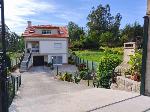 Vista de la fachada y zona ajardinada de Villa Merchy en Combarro