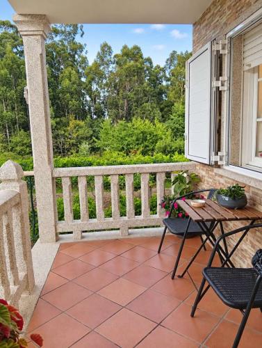 Terraza cubierta de Villa Merchy con vistas al jardín en Combarro